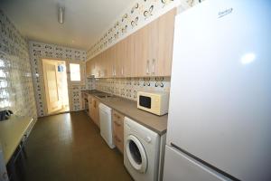 a kitchen with a washing machine and a microwave at Coimbra vista mar Orangecosta in Benicàssim