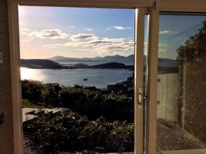 a sliding glass door with a view of a body of water at Tigh Beag in Oban