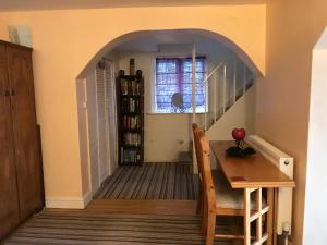 a hallway with a table and a staircase with a window at Flat with Seaview/Garden in Swansea