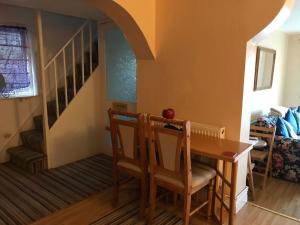 a dining room with a table and chairs and a staircase at Flat with Seaview/Garden in Swansea