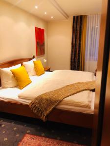- une chambre avec un grand lit et des oreillers jaunes dans l'établissement Da‘ Amici, à Horstmar