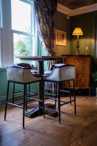 een tafel en stoelen in een kamer met een raam bij Shibden Hall View in Halifax