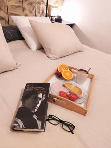 un libro y una bandeja de comida en una cama en Apartamentos Xert Escapadas en Castellón Cerca de Morella y Peñíscola, en Chert