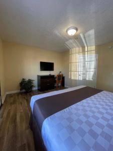 
a bedroom with a bed and a television at Palm Tropics Motel in Glendora
