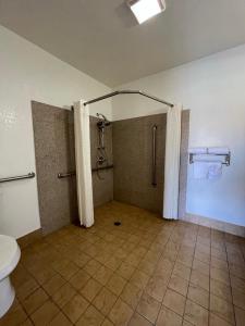 
a bathroom with a toilet, sink, and shower stall at Palm Tropics Motel in Glendora
