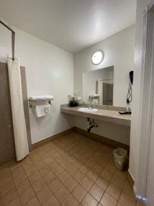 a bathroom with a sink, toilet, and bathtub at Palm Tropics Motel in Glendora