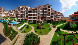 a large apartment building with a garden and a playground at Къща за гости Мускат 2 in Aheloy