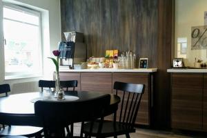 a dining room with a table and chairs and a kitchen at Hotell Nivå in Boden