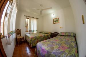 - une chambre avec 2 lits et une fenêtre dans l'établissement Hotel Delfin, à Barra de Navidad