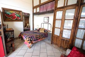 a bedroom with a bed in a room with a door at Majikal B&B - Jacaranda in Cholula