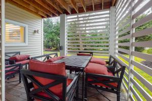 un patio con sillas acolchadas de color rojo y una mesa de madera. en Sea Colony - 58011 Wimbledon, en Bethany Beach