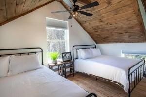 2 Betten in einem Schlafzimmer mit Deckenventilator in der Unterkunft Charming Smoky Mountain Tiny House in Pigeon Forge