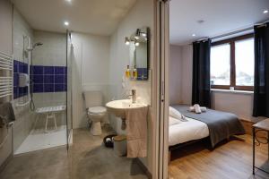 a bathroom with a bed and a sink and a shower at Auberge des deux Moucherolles in Corrençon-en-Vercors