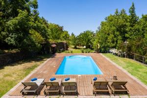 a swimming pool with chairs and a deck with a swimming pool at La Finca in La Orotava