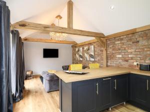 a kitchen with black cabinets and a brick wall at The Forge in Lincoln