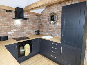 a kitchen with blue cabinets and a brick wall at The Forge in Lincoln