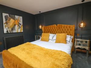 a bedroom with a large bed with a yellow blanket at The Forge in Lincoln