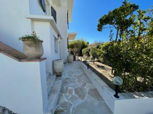 a walkway next to a white building with a plant at Villa Louise-Rose in Villeneuve-Loubet