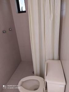 - une petite salle de bains avec des toilettes et un rideau dans l'établissement Hotel Montecarlo, à Ciudad Serdán