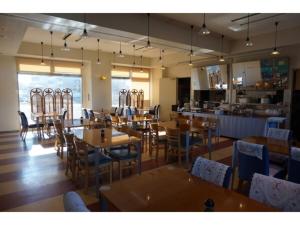 a restaurant with wooden tables and chairs and a kitchen at Plaza Arakawaoki - Vacation STAY 24692v in Tsuchiura