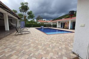 patio z basenem obok domu w obiekcie Casa quinta Las Palmas w mieście Villavicencio