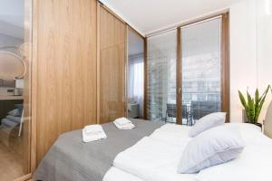a bedroom with two beds with white towels on them at Margo Rentyear Apartments in Gdańsk