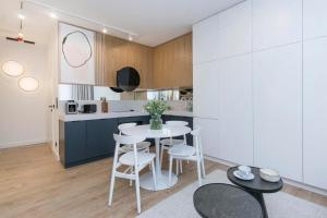 a kitchen with a table and chairs in a room at Margo Rentyear Apartments in Gdańsk