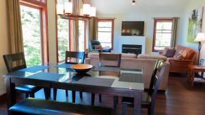 sala de estar con mesa y sofá en Cobble Wood and Bird Sanctuary Guest Houses en Tofino