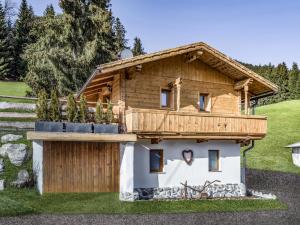 a log house with a balcony on top of it at Chalet Hüttenzauber in Kirchberg in Tirol