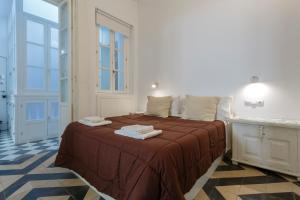 1 dormitorio con 1 cama con toallas en La PEPA1812 by Cadiz4Rentals, en Cádiz