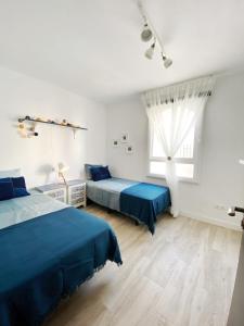 een slaapkamer met 2 bedden en een raam bij Casa Kalameta in Estepona
