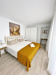 een slaapkamer met een groot bed met een gele deken erop bij Casa Kalameta in Estepona