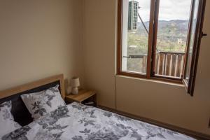 a bedroom with a bed and a large window at Guest house Viki in Veliko Tŭrnovo