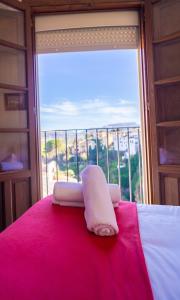 ein weißes Handtuch auf einem Bett vor einem Fenster in der Unterkunft Apartamento Balcones del Tajo 2 in Ronda