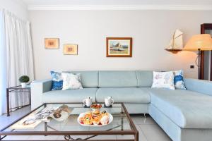 a living room with a blue couch and a table at Luxury BeachFront Mogan in Puerto de Mogán