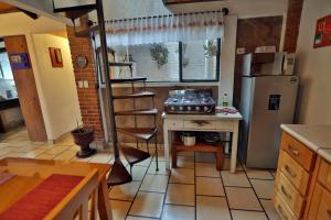 a kitchen with a stove and a refrigerator at Majikal B&B - Cabañita in Cholula