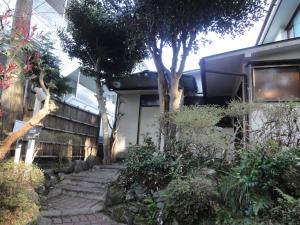 un jardín con un camino de piedra que conduce a una casa en Kinreisou, en Hakone