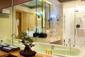 a bathroom with a green tub and a sink at Wyndham Garden Suzhou in Suzhou