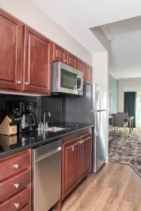 a kitchen with wooden cabinets and a stainless steel refrigerator at Club Wyndham Harbour Lights in San Diego