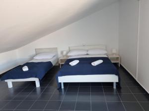 two beds in a room with blue and white at Apartment Sun in Kampor