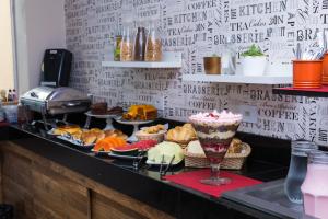 a counter with a bunch of different types of food at Hotel Astória Maringá in Maringá