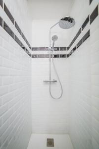 a shower in a bathroom with white tiles at La Dame de Coeur - 1 chambre in Brive-la-Gaillarde