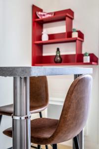 a table with two chairs and a red shelf at La Dame de Coeur - 1 chambre in Brive-la-Gaillarde