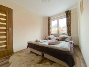 Un dormitorio con una cama con ventana. en Swish Apartment -10 Min to Old Town Gdańsk,PKP & Shopping Mall, en Gdansk