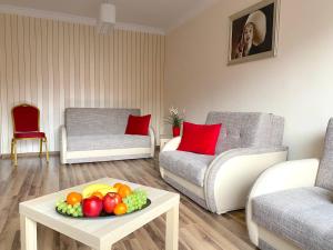 a living room with a bowl of fruit on a table at Swish Apartment in Gdańsk