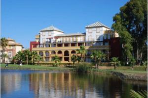 duży budynek obok zbiornika wodnego w obiekcie Apartamento T2, Urbanização Golf, Isla Canela w mieście Huelva