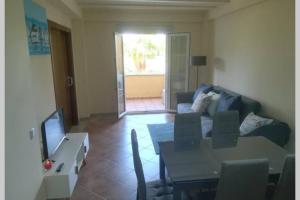 salon z kanapą i stołem z telewizorem w obiekcie Apartamento T2, Urbanização Golf, Isla Canela w mieście Huelva