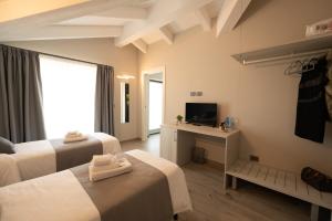 Habitación de hotel con 2 camas y TV en Bed and breakfast Ma.Gi.A, en Cuneo