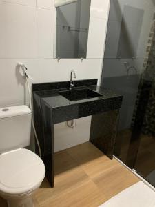 a bathroom with a black sink and a toilet at Raludi Hotel in Barcarena
