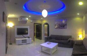 a living room with a couch and a blue ceiling at Al Tal Serviced Apartments in Baljurashi